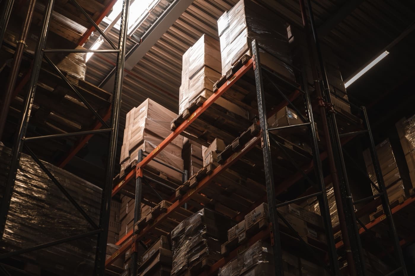 Tall warehouse racking stacked with shrink-wrapped palletised cartons